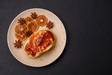Fresh baked pancakes with delicious jam on a ceramic plate