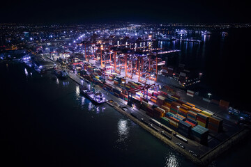 Fototapeta na wymiar Night aerial view of gantry cranes, cargo ships and containers at cargo terminal of large international sea port