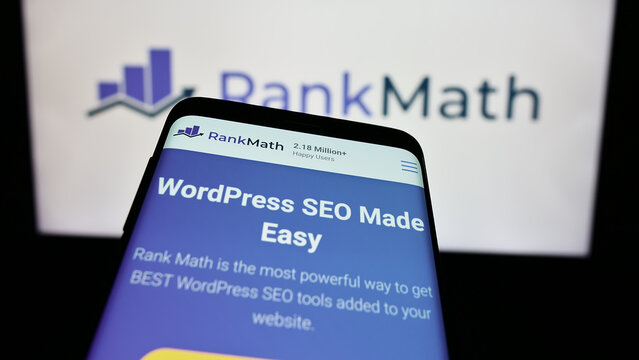 Stuttgart, Germany - 03-12-2024: Mobile phone with website of Indian WordPress SEO company Rank Math in front of business logo. Focus on top-left of phone display.