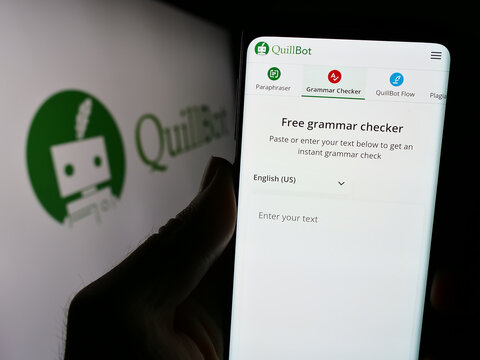 Stuttgart, Germany - 03-12-2024: Person holding cellphone with webpage of US artificial intelligence writing company QuillBot in front of logo. Focus on center of phone display.