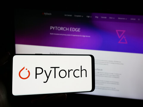 Stuttgart, Germany - 03-12-2024: Person holding mobile phone with logo of machine learning library PyTorch in front of web page. Focus on phone display.