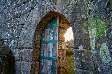 old wooden door of the gate to the medieval Castle Ruins of Castro Laboreiro in the mountains of northern Portugal inside Geras national park.