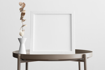 White square frame mockup with an eucalyptus decoration on the beige table.