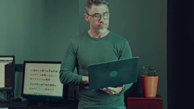 Older man working with tablet computer in home office. Mid adult male in glasses, happy, smiling, looking busy. Casual businessman in office.