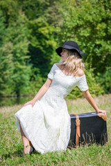 happy girl with a suitcase outdoors at the park