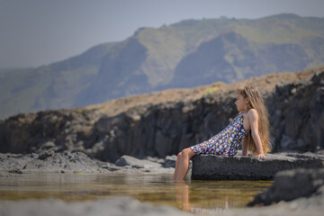 Fototapeta na wymiar Little girl enjoying summer on the beach in natural pools