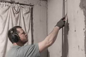 Man Cleans Strobe in Wall for Electrical Wiring with Chisel Expertise,