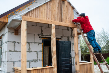 Roofer construction worker working on a roof structure at a house construction site