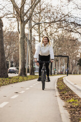 Woman Riding Bike Down Tree-Lined Street