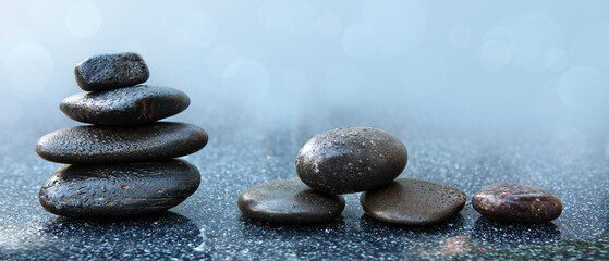 Black spa stones on the gray table background.