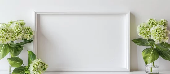Fototapeten Wooden frame with hydrangea flower and white mat on white background. Mock-up. © Vusal