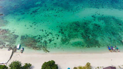 Aerial view of traditional Thai long tail boats at a beach at Koh Phi Phi island, Krabi, Thailand....