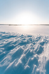 Winterzauber bei Sonnenuntergang: Unberührte Schneelandschaft mit schimmernden Wehen und...