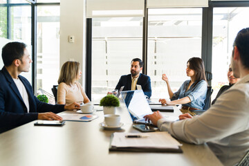 Group of businesspeople sitting in a conference table having a business meeting