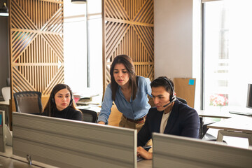 Call center supervisor checking on some sales representatives in the office