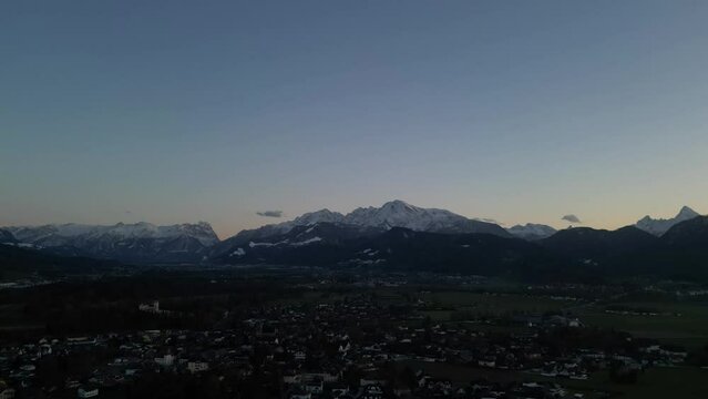 Scenic drone timelapse of sunset over the snowcapped Untersberg Mountain in Salzburg, Austria, while the Shot via drone in 4k. 