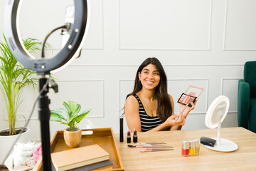 Beauty blogger presenting makeup palette on camera