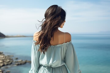 Obraz premium Back view of young brunette woman in standing on seashore