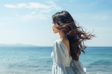 Fototapeta na wymiar Back view of young brunette woman in standing on seashore
