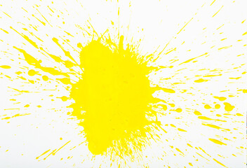 Artistic image of yellow paint spots spilled on background of white paper