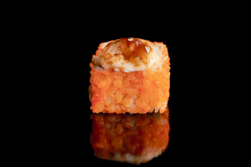 Tempura sushi roll on black background with reflection.