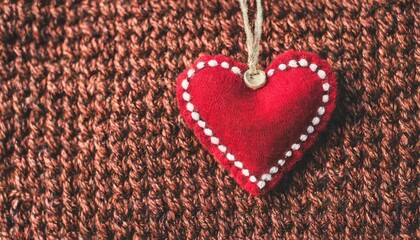 wool sweater texture of red color button and felt heart horizontal background with natural knitted wool material valentine s day backdrop heart shaped patch label copy space for text