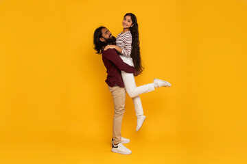 Man carrying woman on yellow background