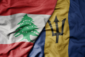 big waving national colorful flag of barbados and national flag of lebanon.