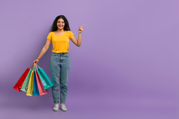 Happy shopper pointing on purple