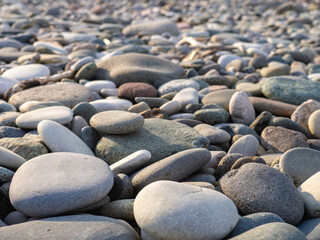 Gray sand and stones on the beach. Stone in the foreground.