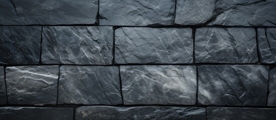 A close up of a rectangular black cobblestone wall with a grey road surface, creating a parallel pattern in monochrome photography