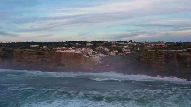 White Houses of Azenhas do Mar Village in Portugal. Cliffs and Waves of Atlantic Ocean. Aerial View. Orbiting