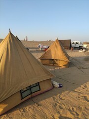 Campement de tente en plein milieu d'un désert, soleil couchant, reflet de lumière, camping entre amis, splot indien incourtounable, plaisir détente touristique, que du sable à l'horizon  - obrazy, fototapety, plakaty