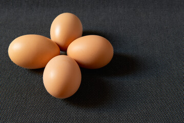 Fresh brown chicken eggs on grey background.