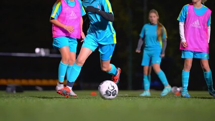 teenage Caucasian girls playing football at the late evening practice, full shot, teenage lifestyle. High quality 4k footage