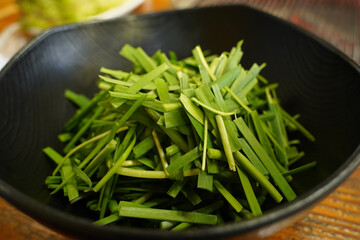 A black plate full of fresh chives