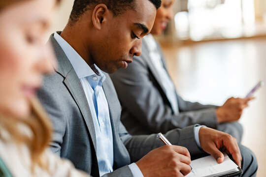 A diverse group of multi-ethnic people waiting for a job interview in front of a corporate office