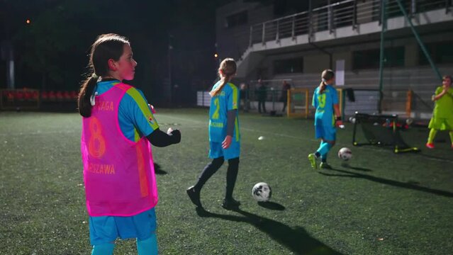School age Caucasian girls having practice in soccer in the late evening, achool championship. High quality 4k footage