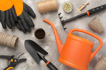 Orange gardening tools on concrete background, top view