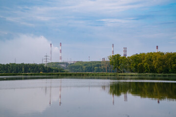 Obraz premium River Dividing Green Village and Factory with Large Emitting Chimneys