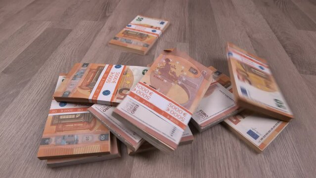 Euro stacks fall onto a wooden floor. Wealth, earning and winning concept.