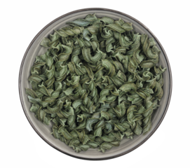 Uncooked fusilli spirulina in bowl, organic dry pasta isolated on white, top view