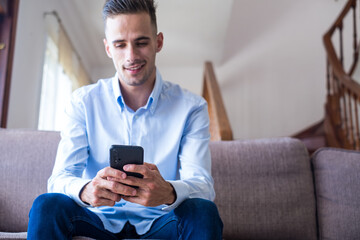 Excited smiling man looking at phone screen, using mobile app, typing message in social network,...