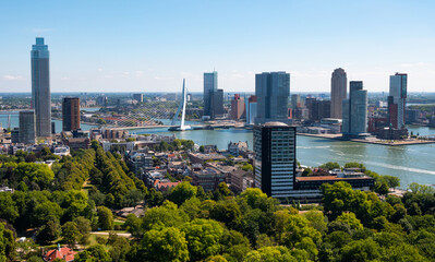 Scenic aerial view of modern cityscape of Rotterdam on both banks of Nieuwe Maas connected by Erasmus cable-stayed bridge on summer day, Netherlands.. - 761871180