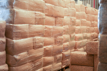 Vacuum-packed wood shavings lie on pallets in the warehouse of the factory