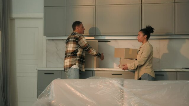 Upset frustrated home owners African american family sad man and woman couple pack cardboard boxes repair dwelling moving day relocation move out from apartment division of property loan debt eviction