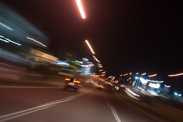 Driving through Brisbane at nighttime creates a mesmerizing motion blur, as city lights streak...