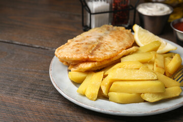 Delicious fish and chips on wooden table, closeup