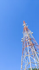 Low angle view of telecommunication tower under clear blue sky. Wireless communication and information technology concept