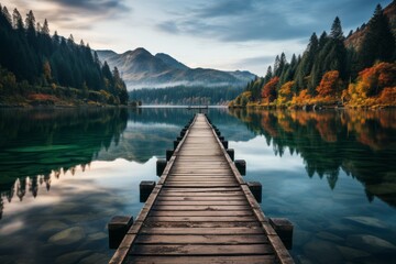 Wooden pier by lake with mountain backdrop, surrounded by natural landscape - obrazy, fototapety, plakaty